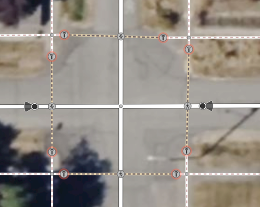 A screenshot of the OpenStreetMap iD editor where, at each corner of a four-way road intersection, a pair of guard *t*owers has been inserted instead of a pair of *l*owered crossings